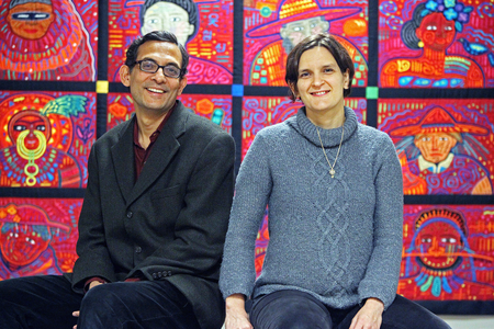 CAMBRIDGE - NOVEMBER 16: Abhijit Banerjee, left, and Esther Duflo, right, in the offices of the J-PAL Poverty Action Lab at MIT. Behind them is a quilt called "The Peoples of the World" by Fumiko Nakayama that hangs in the lobby of the offices. (Photo by Jim Davis/The Boston Globe via Getty Images)