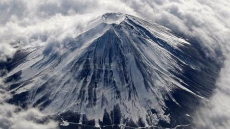 japan s mount fuji covered with snow and surrounded by cloud is seen from an airplane 1244843